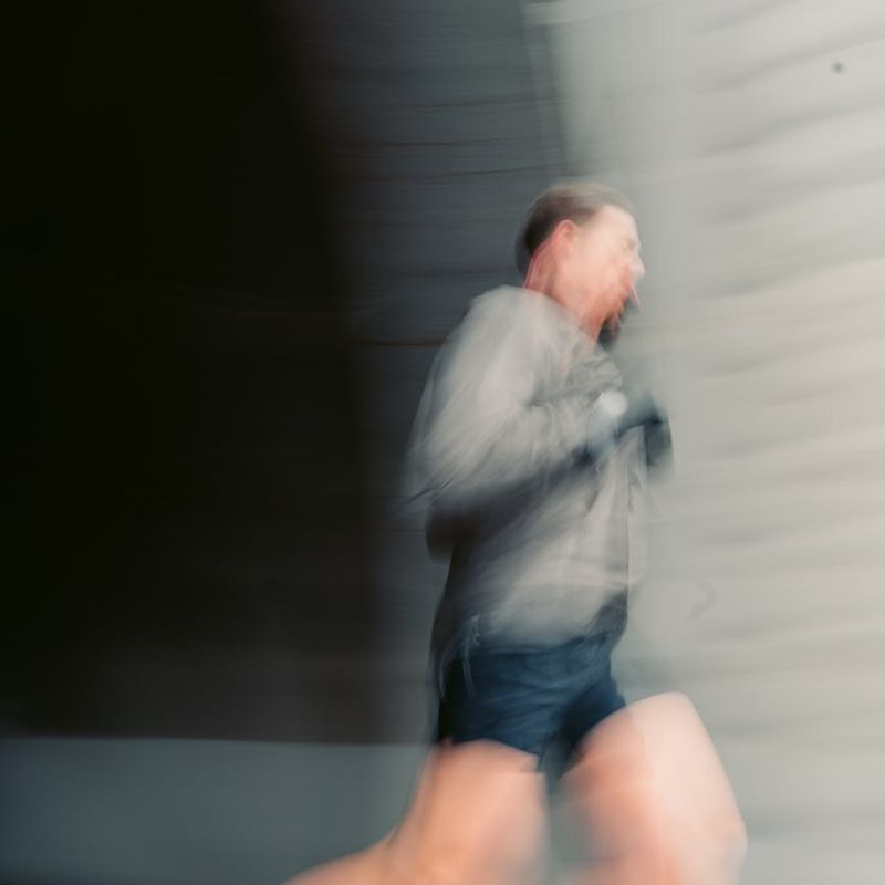 Man in a dynamic movement pose, captured with motion blur.